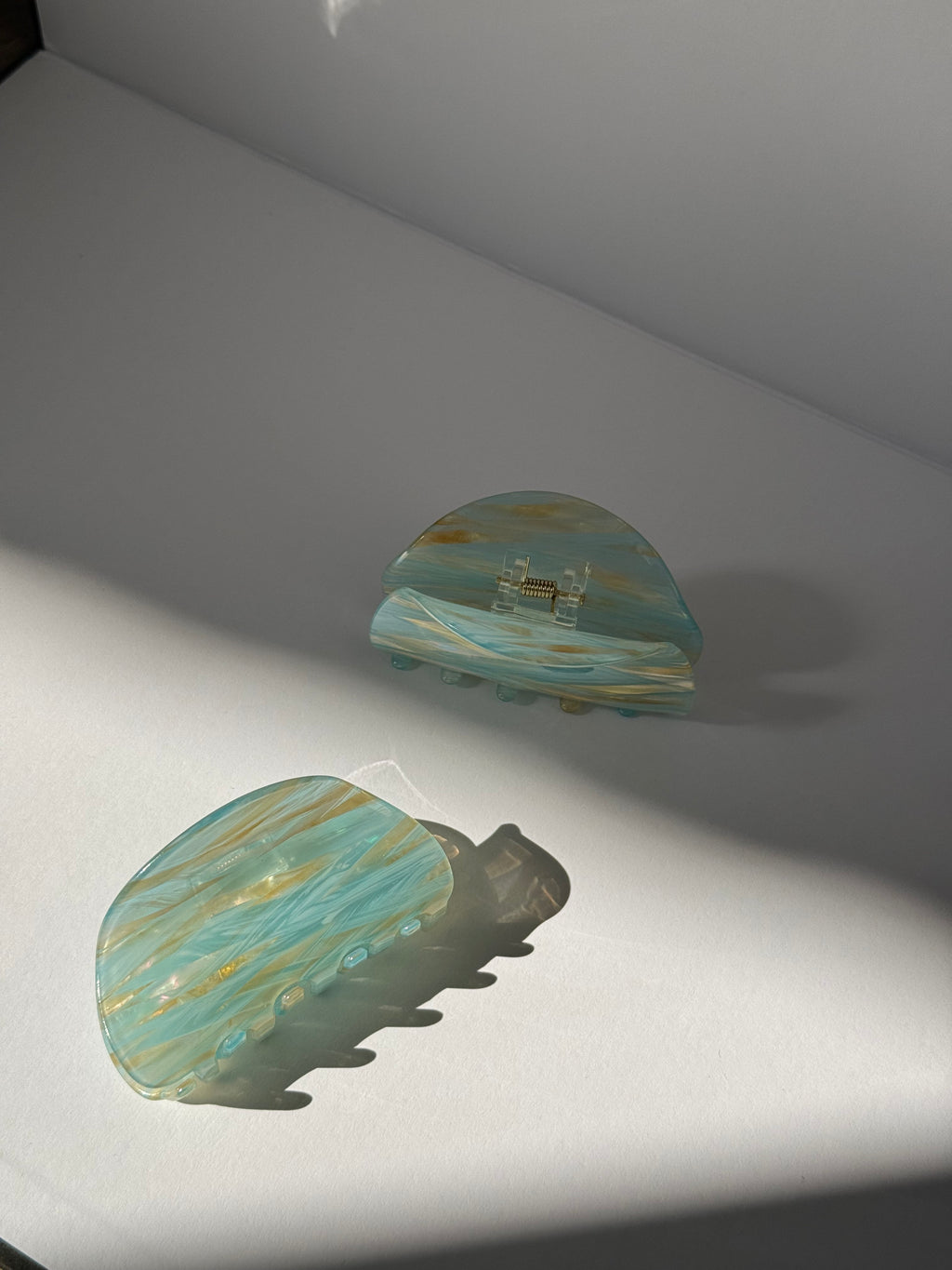 Pair of earrings with  blue and gold design on a light gray background