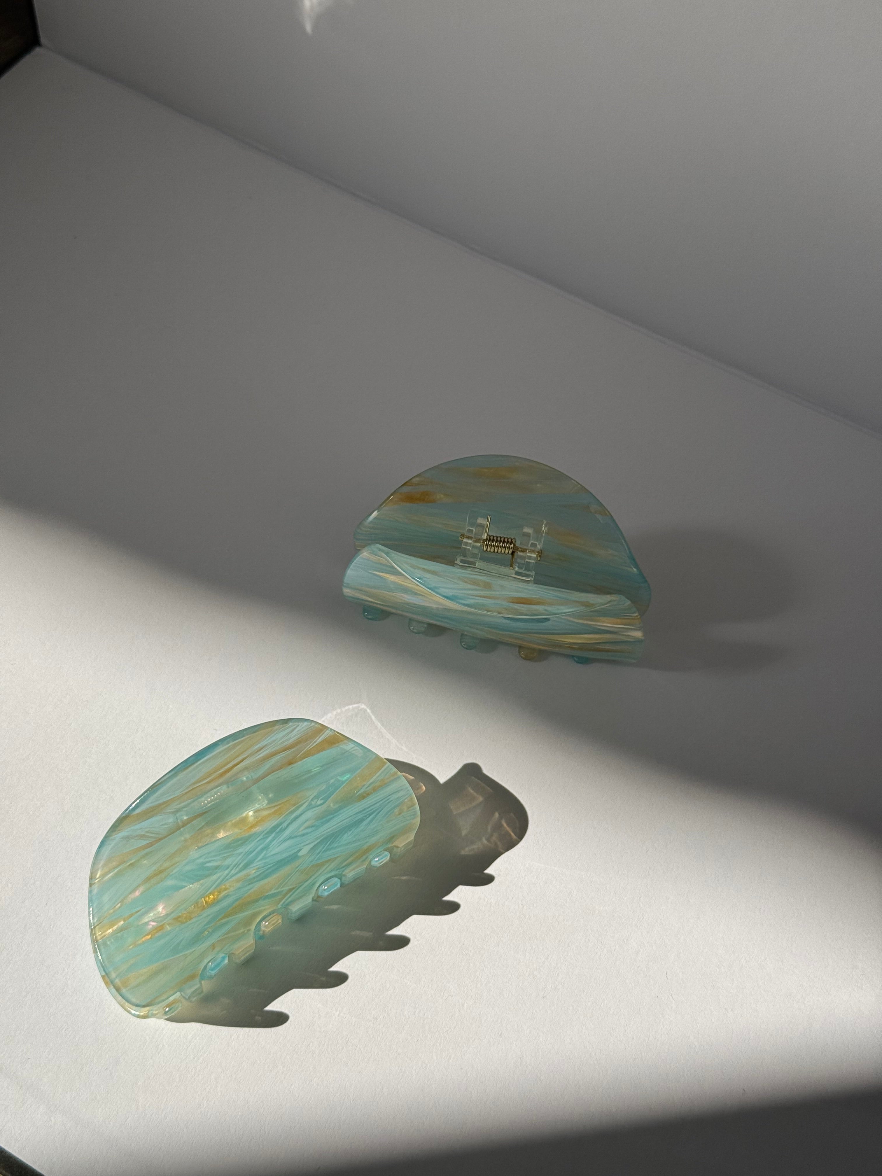 Pair of earrings with  blue and gold design on a light gray background
